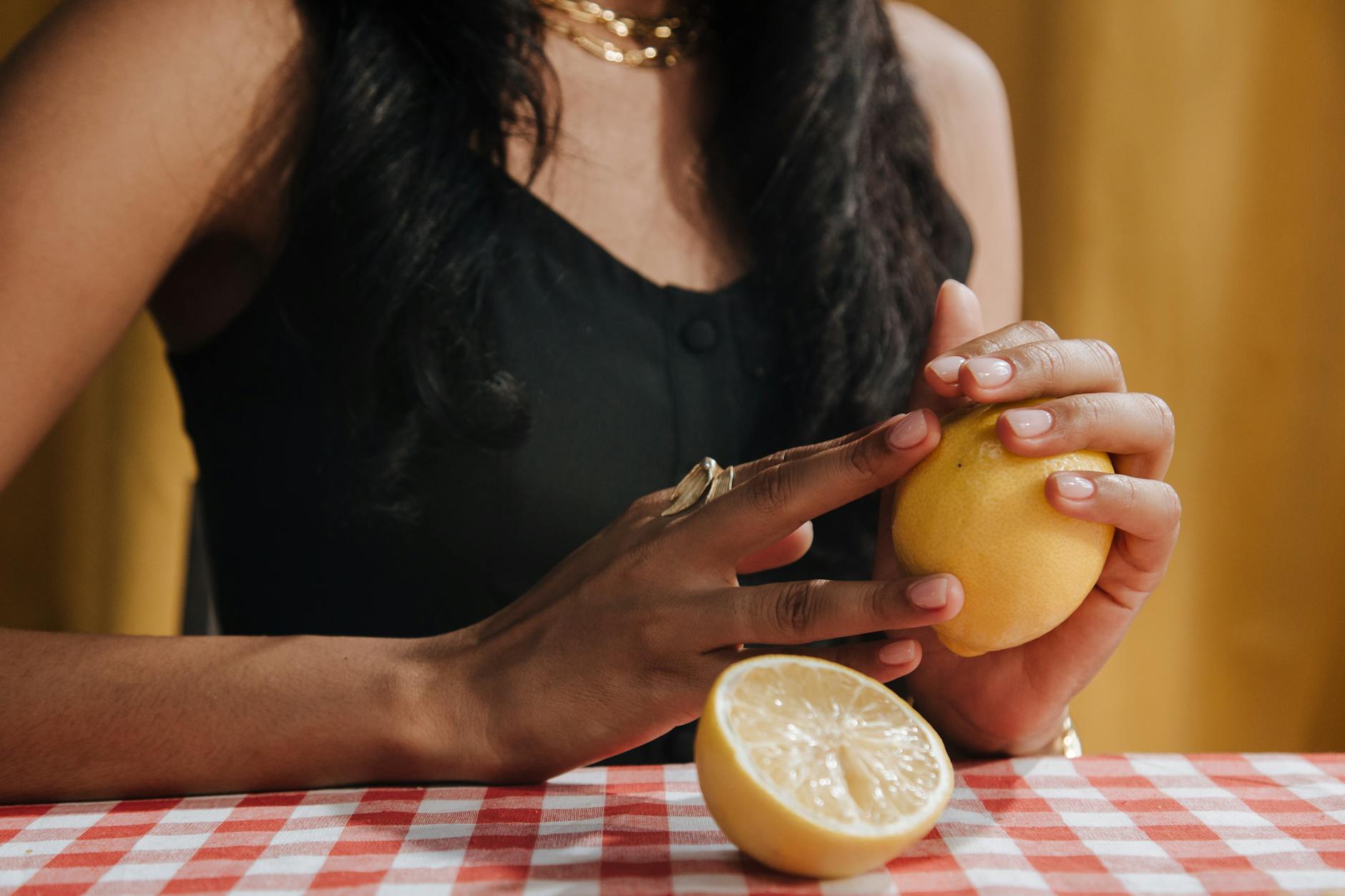 A close-up of a hand holding an orange vibrator against a minimalistic purple backdrop, showcasing modern sensuality.