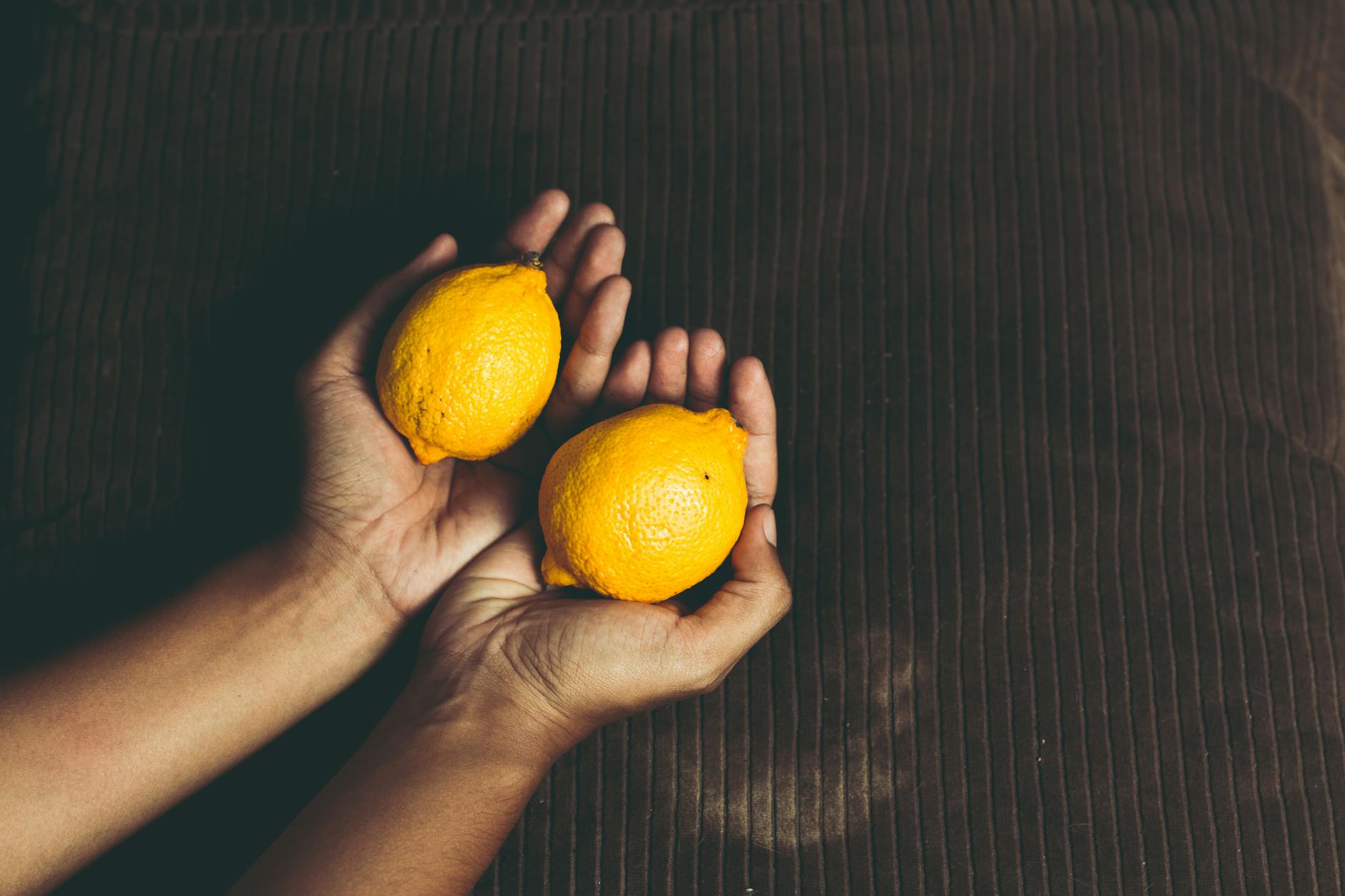 Bright ripe lemons arranged on a pastel background, symbolizing quick, accessible pleasure.