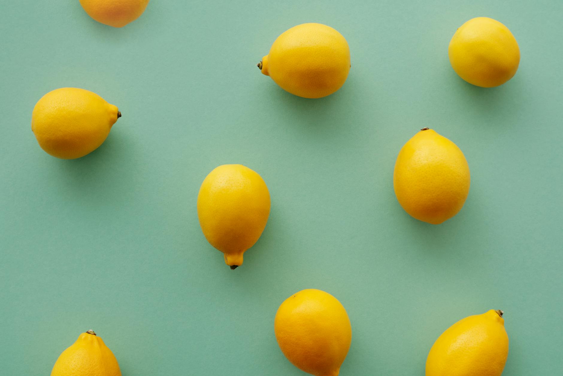 Fresh bright yellow lemons on a soft pastel background, symbolizing refreshing intimacy and natural connection