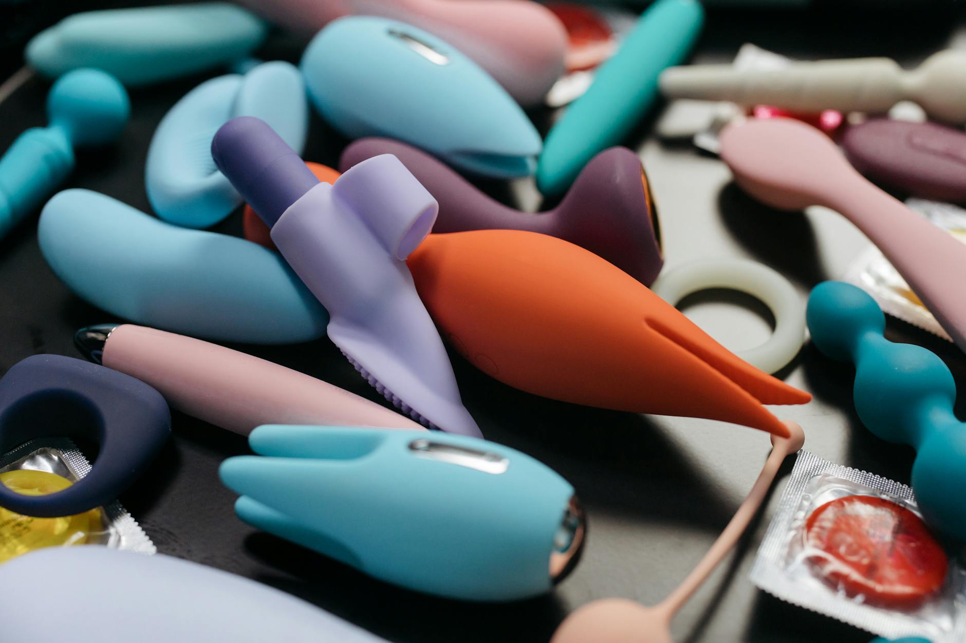 Una varietà di vibratori adulti colorati e anelli disposti in una composizione ravvicinata