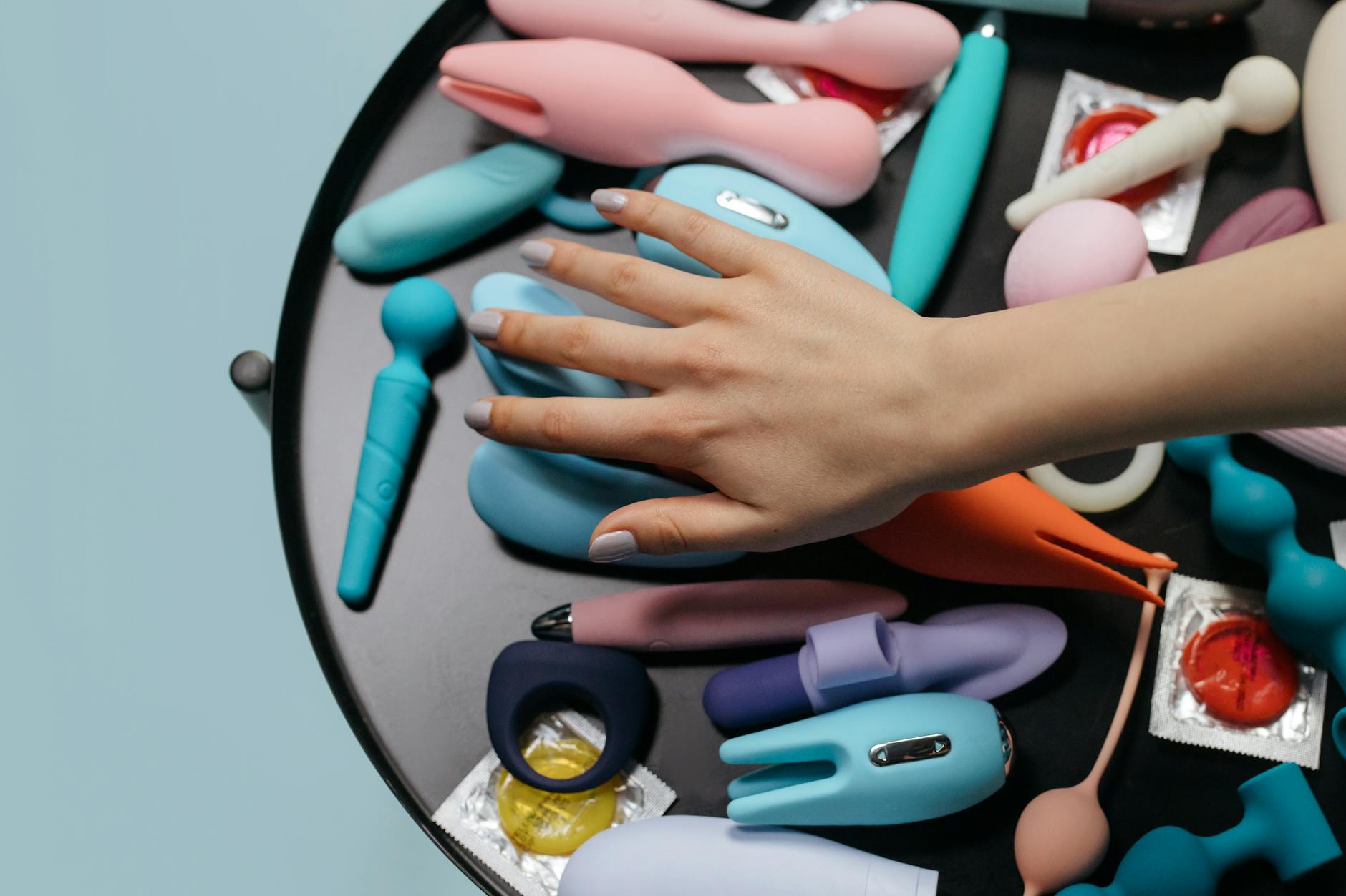 Blue silicone vibrator held in hand, representing post-recovery pleasure and sensation