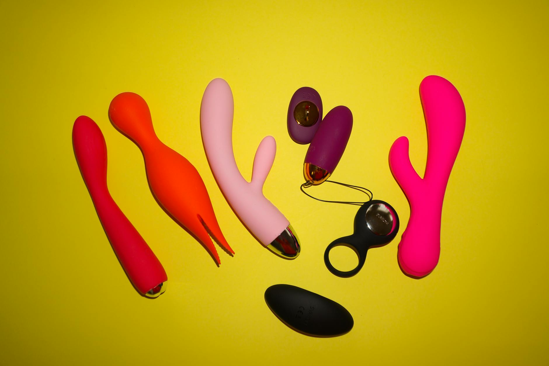 A hand holding a blue silicone vibrator against a purple background, symbolizing self-love and bodily autonomy after relationship trauma.