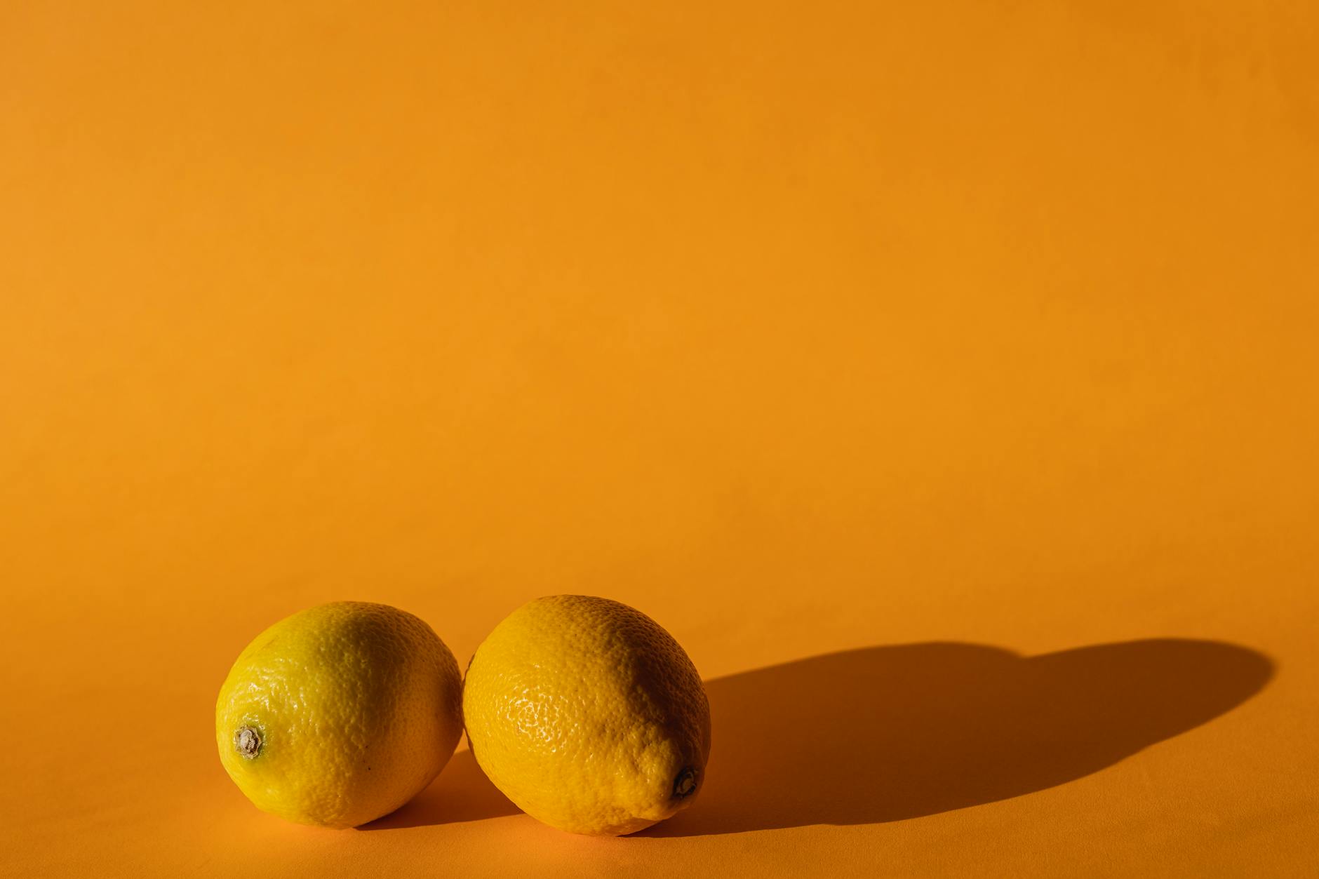 A silicone lemon vibrator held in hand against a purple background, representing self-pleasure and reconnection